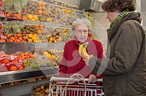 Caregiver helps senior woman while shopping