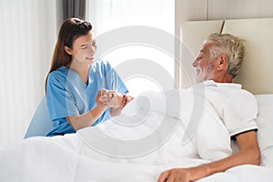 Caregiver holding elderly man patient hand