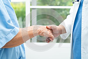 Caregiver holding hands Asian elderly woman patient with love, care, encourage and empathy at nursing hospital, healthy strong