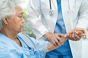 Caregiver holding hands Asian elderly woman patient with love, care, encourage and empathy at nursing hospital, healthy strong