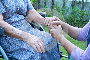 Caregiver holding hands Asian senior or elderly old lady woman patient with love, care, encourage and empathy at nursing hospital