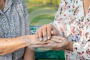 Caregiver holding hands Asian senior or elderly old lady woman patient with love, care, encourage and empathy at nursing hospital