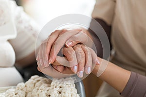 Caregiver holding senior woman`s hands