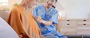 Caregiver holding stethoscope listening old patient during homecare visit. Caregiver or doctor checking heartbeat