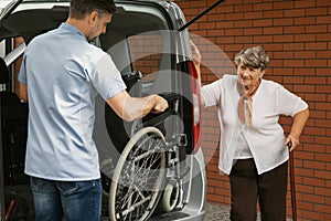 Caregiver holding wheelchair in the car
