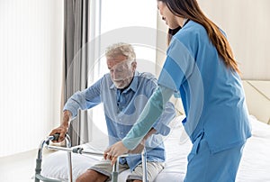 Caregiver nurse take care a Senior patient. Nurse helping senior Man hand holding walker trying to walk