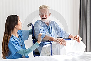 Caregiver nurse take care a Senior patient sit on wheelchair. Nurse helping senior Man