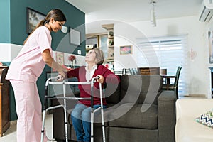 Caregiver Supporting Elderly Disabled Patient At Home