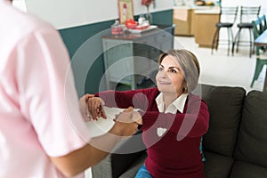 Caregiver Supporting Senior Patient To Sit