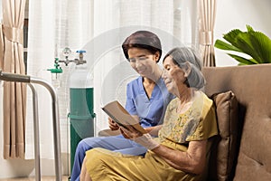 Caregiver takecare elderly woman while wearing oxygen nasal cannula at home