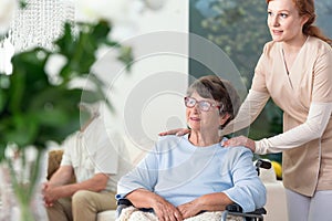 Caregiver taking care of disabled senior woman