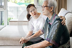 Caregiver woman is taking care,support of sad senior, depressed elderly looking away outside waiting for her family to visit at