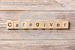 Caregiver word written on wood block. Caregiver text on table, concept
