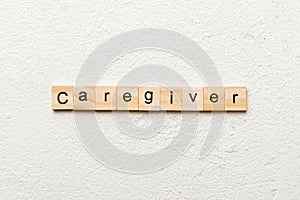 Caregiver word written on wood block. Caregiver text on table, concept photo
