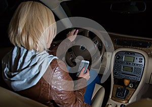 Careless female driver checking her phone while driving.