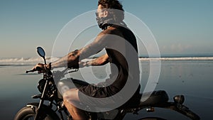 Careless loner biker riding along the ocean coast