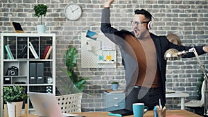 Careless office worker dancing listening to music throwing papers and notebook