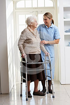 Carer Helping Elderly Senior Woman Using Walking F