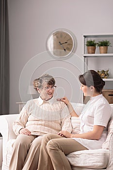 Carer supporting elderly woman