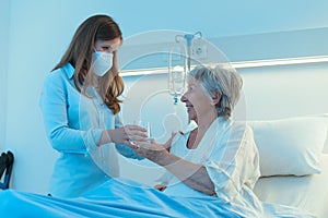 Carer wearing a mask giving a patient medication