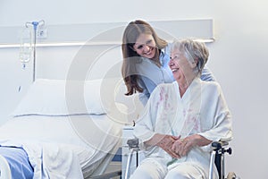 Carer wheeling an elderly woman in a wheelchair