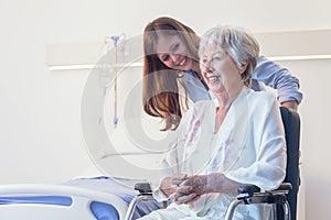 Carer wheeling an elderly woman in a wheelchair