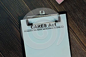 Cares Act write on a paperwork isolated on Wooden Table photo
