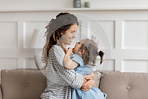 Caress mom cuddles little daughter expressing love and cherish photo