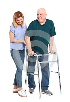 Caretaker helping elderly man with walking frame on white