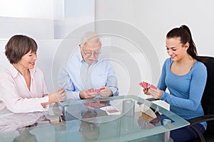 Caretaker Playing Cards With Senior Couple photo