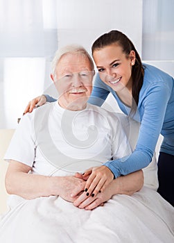 Caretaker with senior man at nursing home photo