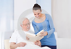 Caretaker and senior man reading book