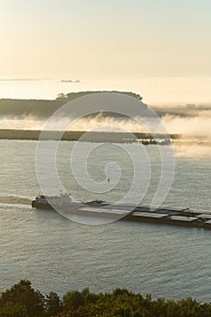 Cargo barge DMITRIY KALININ on the Danube river early in the morning, fog over the