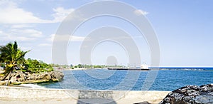 Cargo boat arriving at the entrance of the port of Santo Domingo, Dominican Republic with a tropical blue sea