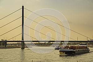 A cargo boat travelling along the river Rhine at dusk in Dusseldorf, Germany.