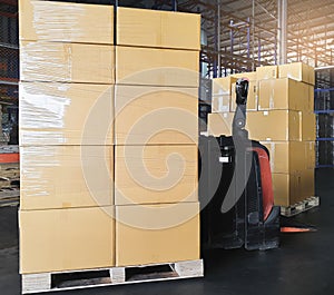 Cargo boxes shipment, Manufacturing and warehousing. Stack of cardboard boxes on pallet and forklift pallet jack in the warehouse