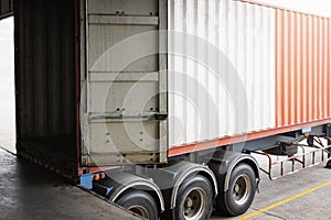 Cargo container truck loading at dock warehouse. Trailer docking stations. Industry freight truck transport.