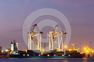 Cargo cranes in industrial port at twilight