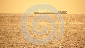 Cargo and dredging industrial ships sailing in to sea horizon. One large cargo ship grain carrier tanker in sea on sunny