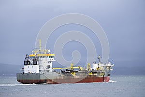 Cargo export container carrier ship vessel on sea under dark sky