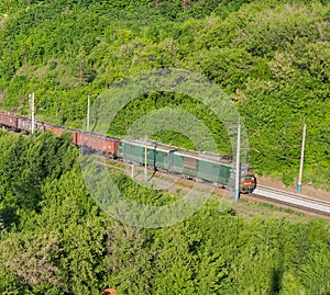 The cargo freight train moves by rail in the evening
