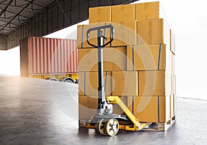 Cargo freight truck, Delivery. Hand pallet jack with stack cardboard boxes on pallet waiting to load into cargo container.