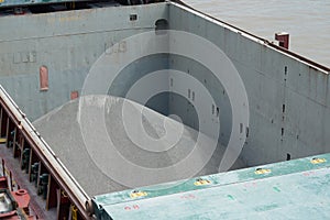 Cargo hold of bulk carrier ship full of bulk cargo