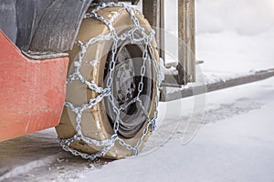 Cargo loader in winter on snow. The loader ride on snow with chains on the wheels to reduce slippage and spin. Driving