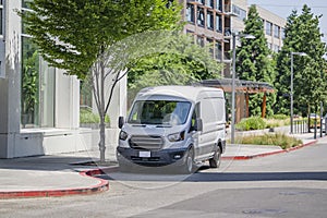 Cargo mini van for delivery and small business use standing on the urban city street with multilevel apartment buildings photo