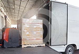 Cargo pallet shipment, Freight truck, Delivery. Electric forklift pallet jack and cargo pallet boxes loading into cargo truck.