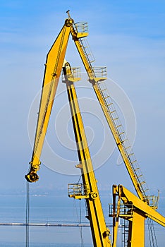 Cargo port cranes. Foggy. Sea backplane