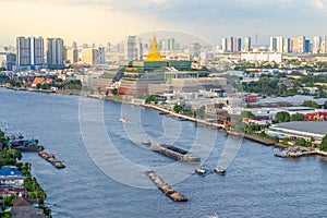 Cargo and sand ships pass the new Thai parliament on the Chao Phraya River