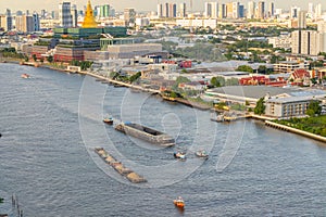 Cargo and sand ships pass the new Thai parliament on the Chao Phraya River