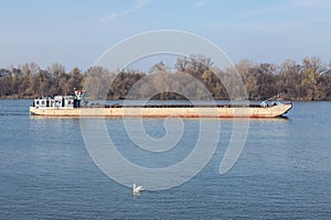 Cargo ship, a barge, cruising on the Danube river in Belgrade, Serbia, in belgrade, carrying construction material.